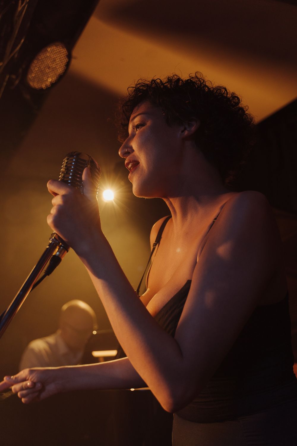 Singer performing under stage lighting; illustrative photography